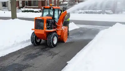 Professional snow blower clearing residential driveway, efficient snow removal service in Oak Park, IL